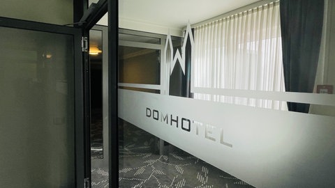 Auf einer Glastür ist das Logo des sanierten Wormser Domhotels zu sehen.