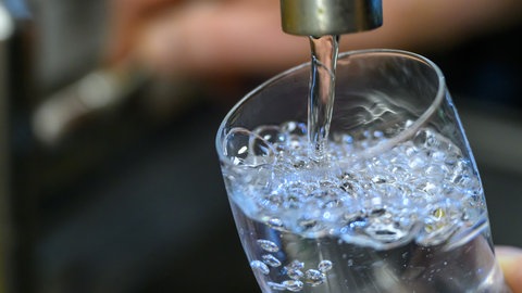 Trinkwasser läuft aus dem Hahn in ein Glas. In Wiesbaden muss das Wasser nicht mehr abgekocht werden.