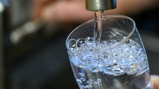Trinkwasser läuft aus dem Hahn in ein Glas. In Wiesbaden muss das Wasser nicht mehr abgekocht werden.