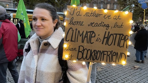 Diese junge Frau hat ein Plakat selbst gebastelt und beleuchtet.