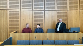 Drei Männer im Landgericht Mainz. Der links sitzende Angeklagte ist vom Vorwurf des Totschlags im Mainzer Hartenbergpark freigesprochen worden.