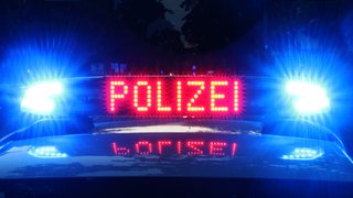 Ein Polizeiauto hat bei Nacht das Blaulicht an.