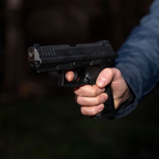 Eine Person hält eine Schusswaffe in der Hand.