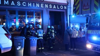 Feuerwehrleute stehen vor einer Bar in der Mainzer-Altstadt. Sie retteten eine Katze aus einer brennenden Wohnung