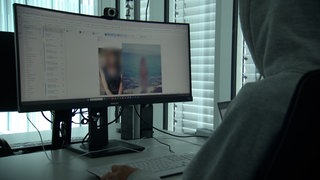 Ein Mann sitzt vor einem Bildschirm. Bei einem Fall von Sextortion wurde ein Mainzer mit intimen Fotos erpresst