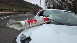 Ein Stück einer Bahnschranke steckt in der Frontscheibe eines Autos. Bei dem Unfall am Bahnübergang in Nackenheim sind zwei Menschen verletzt worden. 