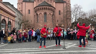 Hunderte Menschen stehen am Mainzer Dom und singen gemeinsam mit den Humbas die Fastnachtshymne "Im Schatten des Doms"