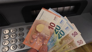 Betrüger drängen Opfer dazu, Geld am Automaten abzuheben.