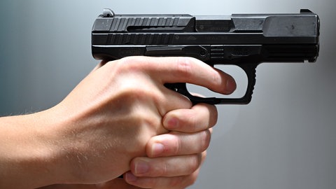 Ein Mann hält eine Pistole in der Hand und zielt damit auf eine Frau in Mainz.
