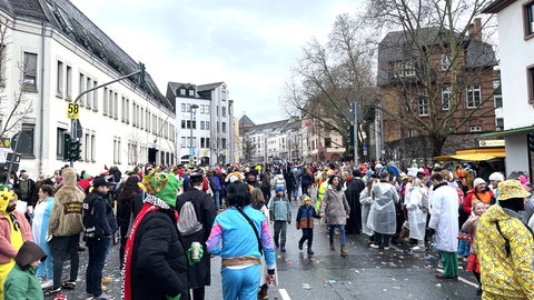 Der Rosenmontagszug ist fast rum - vor vielen Kneipen stehen schon Schlangen von Menschen, die dort weiterfeiern wollen.