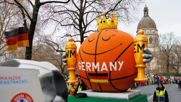 Motivwagen beim Mainzer Rosenmontagszug. Ein großer Basketball hält zwei Pokale: Nur kein Neid, ist das Motto dieses Motivwagens. Welt- und Europameister ist das deutsche Basketball-Nationalteam.