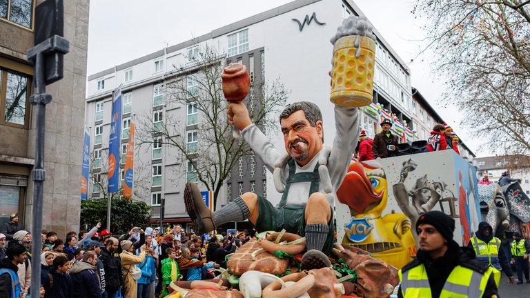 Motivwagen beim Mainzer Rosenmontagszug mit Markus Söder auf einem Lebensmittelberg