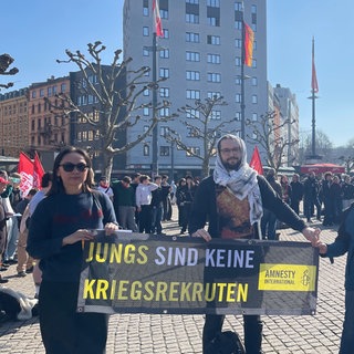 Schülerinnen und Schüler mit Bannern demonstrieren am Mainzer Hauptbahnhof gegen eine mögliche Wehrpflicht