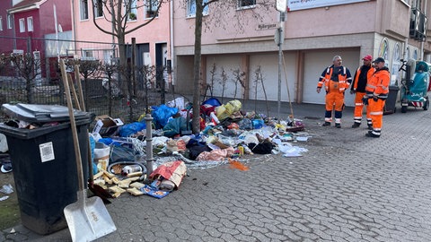 Mitarbeiter der Stadtreinigung Bad Kreuznach stehen an einem der vielen illegalen Müllberge der Stadt.