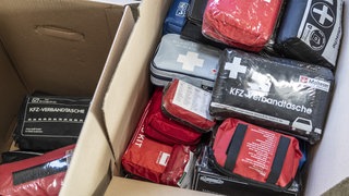 In einem Karton liegen Kfz-Verbandstaschen, die noch verwendet werden können. 