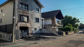 Der Tatort in Ober-Olm. Vor einem Wohnhaus sind die Spuren des Feuers zu sehen. Der mutmaßliche Täter muss sich nun wegen Brandstiftung und Erpressung vor Gericht verantworten. 