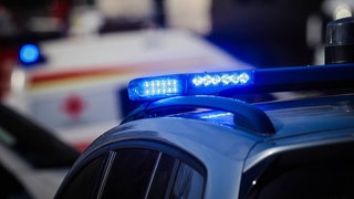Blaulicht von einem Polizei- und einem Rettungswagen. (Symbol) In Wöllstein ist eine Mann von einem Lkw überrollt und tödlich verletzt worden. 