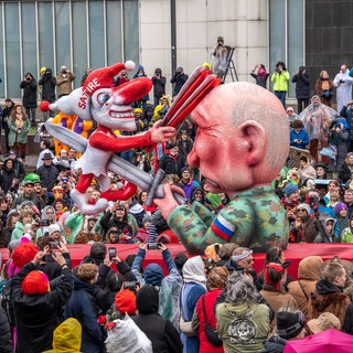 Ein Fastnachtswagen von Jacques Tilly zeigt, wie der russische Präsident Putin eine Clown-Figur mit der Aufschrift "Satire" ersticht.