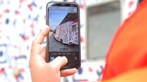 Bei so gut wie jeden Unfall behindern mittlerweile Schaulustige die Rettungsarbeiten. Ein Mann filmt mit seinen Smartphone einen rettungswagen (Symbolbild)
