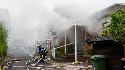 Nach dem Brand einer Sauna hängt rund um das Haus in Mainz-Finthen starker Rauch.