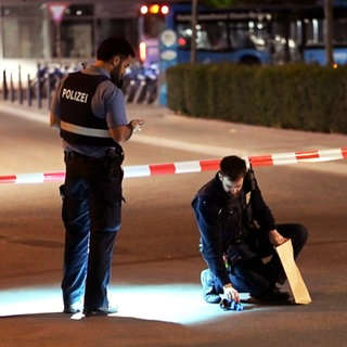 Polizisten hinter einem Absperrband, die einen verdächtigen Gegenstand eintüten. Am Wormser Hauptbahnhof hat es eine Messer-Attacke gegeben. 