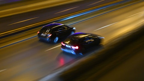 Zwei Autos rasen auf der Autobahn nebeneinander her. (Symbol) In Mainz stehen zwei Männer vor Gericht, die sich auf der A63 ein illegales Rennen geliefert haben sollen.  