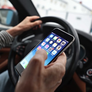 Ein Autofahrer hält während der Fahrt ein Handy in der Hand. Die Polizei hat in Mainz solche Verstöße kontrolliert.