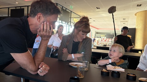 Jürgen Klopp im Gespräch mit dem dreijährigen Silas und daneben die Mutter Hannah Eckhoff Heisser beim Mutmacher-Abend. 