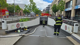 Feuerwehrleute und Schlauch vor einer Tiefgarage: In Mainz hat ein Auto in einer Tiefgarage gebrannt. 