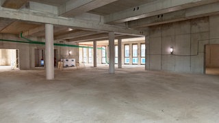 Ein leerer Raum in einem Rohbau der neuen Anna Seghers-Bücherei in Mainz, Boden und Wände sind aus grauem Beton.
