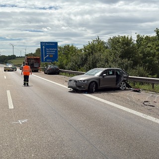 Nach einem Unfall auf der A61 bei Gau-Bickelheim steht ein Auto demoliert auf dem Seitenstreifen.