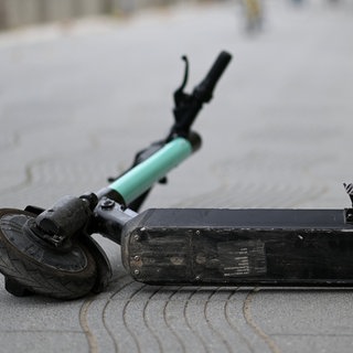 Ein E-Scooter liegt auf einer Straße.