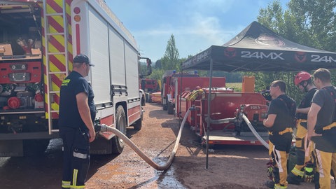 Einsatzkräfte in sicherem Abstand zum Waldbrand bei Traisen