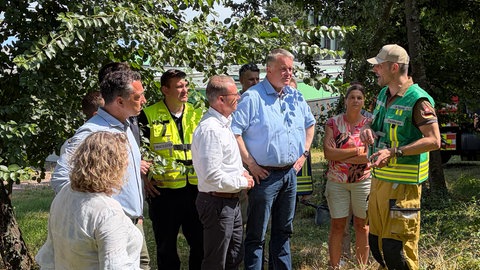 Der rheinland-pfälzische Ministerpräsident Gordon Schnieder im Kreis von Einsatzkräften. Er besucht die Helferinnen und Helfer vor Ort in Traisen. 