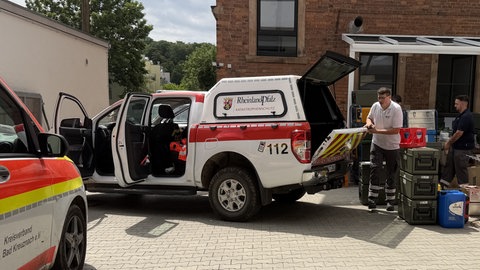 Kisten mit Verpflegung werden in ein Auto des Roten Kreuz' verladen. 