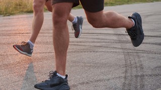 Zwei Männer laufen eine Straße entlang - auf der B9 bei Nackenheim mussten Jogger von der Polizei gestoppt worden.