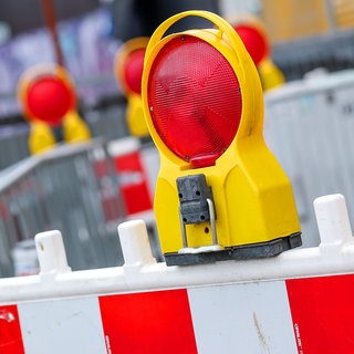 Rot-weiße Warnbaken kennzeichnen eine gesperrte Straße.