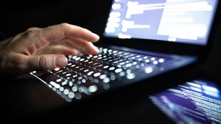 Finger tippen auf der Tastatur eines Notebooks 
