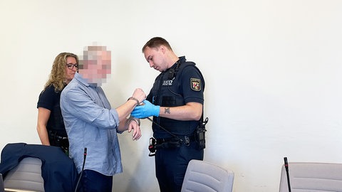 Vor der Urteilsverkündung wird der 70-Jährige mit Handschellen in den Gerichtssaal geführt.