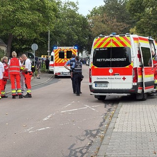 Zahlreiche Einsatzkräfte von Rettungsdiensten und Anwohner vor dem Wohnhaus in Alzey, das wegen Kohlenmonoxid evakuiert werden musste.