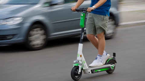 Symbolfoto: Ein Mann faehrt mit einem E-Scooter des Fahrrad- und E-Rollervermieters Lime im Strassenverkehr. Die Mainzer Polizei kontrolliert sie verstärkt. 