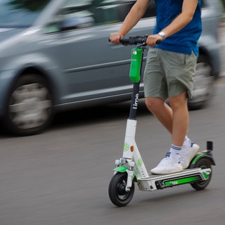 Symbolfoto: Ein Mann faehrt mit einem E-Scooter des Fahrrad- und E-Rollervermieters Lime im Strassenverkehr. Die Mainzer Polizei kontrolliert sie verstärkt. 
