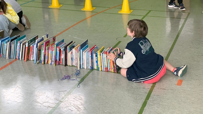 Die Kinder der Grundschule Nittel haben seit Ostern viele Bücher gelesen und stellen sie in die Turnhalle.