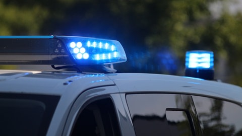 Polizeiwagen mit Blaulicht bei Dunkelheit.