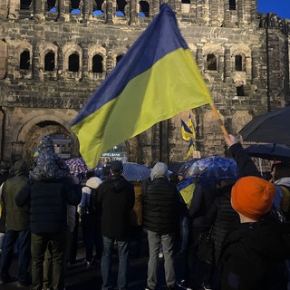 Friedlich protestierten die Menschen am Montagabend zum Anlass des dritten Jahrestag des russischen Überfalls auf die Ukraine vor der Porta Nigra. 