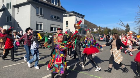 Narren springen, singen und tanzen durch die Straßen in Trier-Biewer. Das Schauspiel zieht jedes Jahr viele Zuschauer an. 