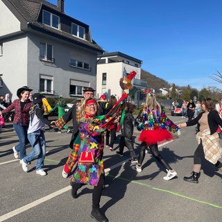 Narren springen, singen und tanzen durch die Straßen in Trier-Biewer. Das Schauspiel zieht jedes Jahr viele Zuschauer an. 