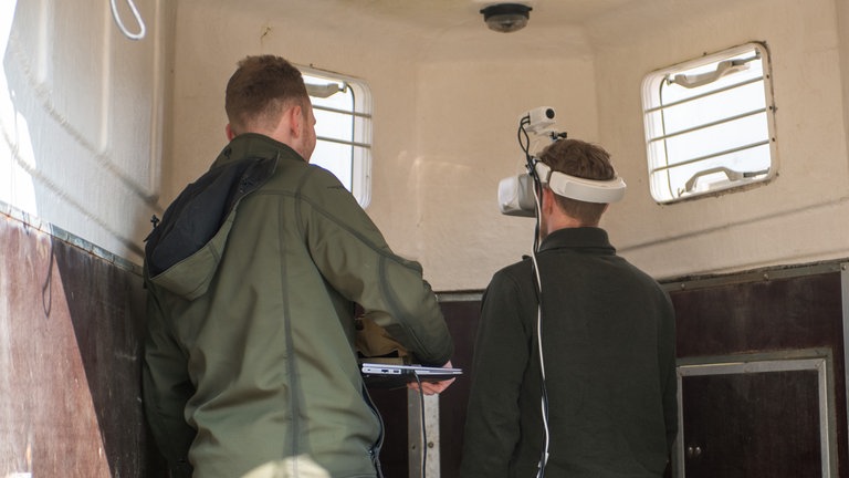 Entfernungen lassen sich mit der VR Brille nur schwer ausmachen. Deswegen laufen einige fast gegen die Wand des Hängers.