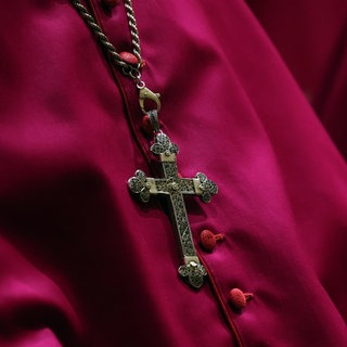 Ein Kreuz an der Halskette eines katholischen Geistlichen. In Montabaur muss sich ein Priester vor Gericht verantworten, weil er sich an einer Achtjährigen vergangen haben soll.