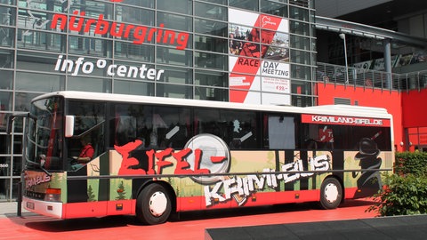 Ein bedeutender Stopp auf den Touren mit dem Krimibus war der Nürburgring. Jacques Berndorf hat einen seiner Krimis aus der Eifel über die Steuerverschwendung beim Bau des Freizeitzentrums an der Rennstrecke geschrieben.